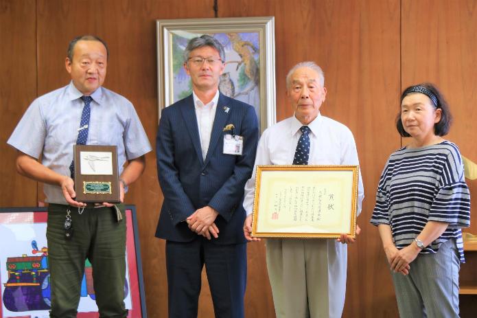 日本鳥類保護連盟会長賞受賞の賞状と楯を持つ白鳥愛護会様と市長の写真