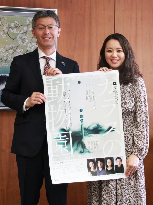 公演のポスターを一緒に持つ市長と永宝さんの写真