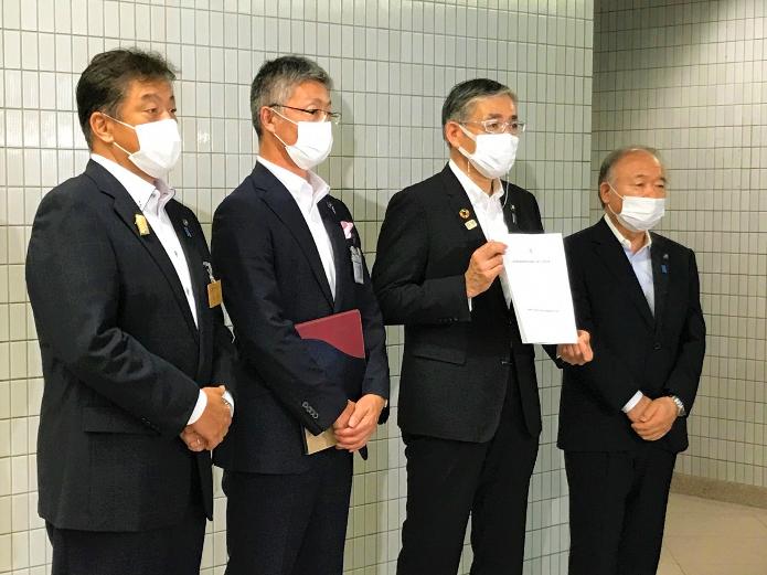 新潟県市長会役員4名が横に並び、報道陣からの取材を受けている写真