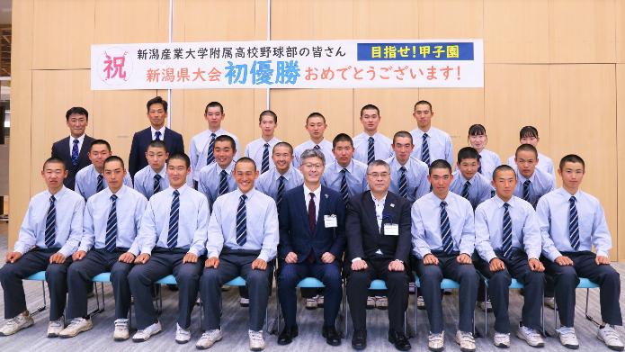 新潟産業大学附属高校野球部の選手、先生方、マネージャー、市長、教育長が3段で並んでいる写真