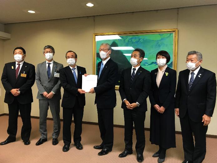 市長を含む市長会のメンバー6名が、大きな絵の前で花角新潟県知事に要望書を手渡している写真