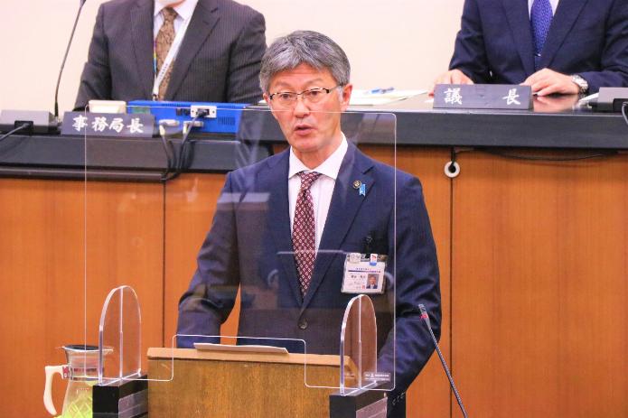 市長が、議場の演台で、所信表明演説を行っている写真