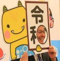 令和パネルのくりぬかれた穴から顔を出す市長の写真