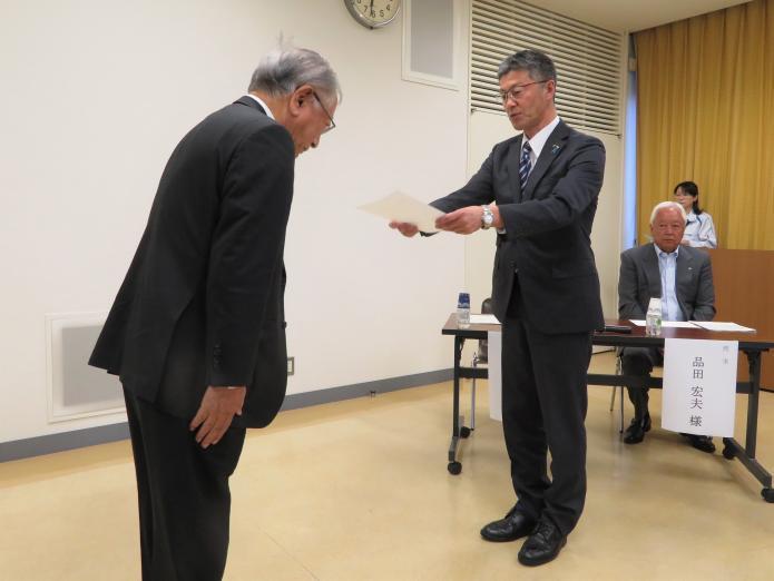 地域の会定例会で新任委員に依頼状を交付している市長の写真