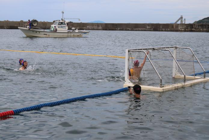 海に設置された水球コートで、ゴールに向かって始球シュートをする市長の写真