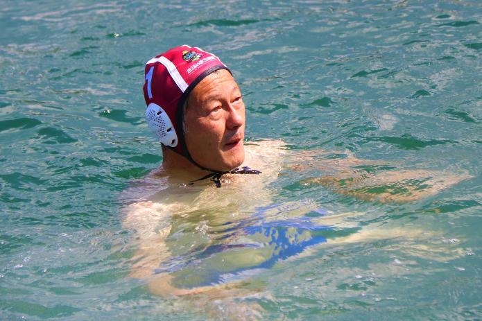 海の中で、市長が水着と水球帽を身につけて、浮かんでいるところ