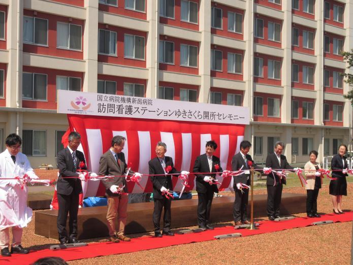 屋外で病院長や来賓が横一列に並びテープカットをする様子の写真