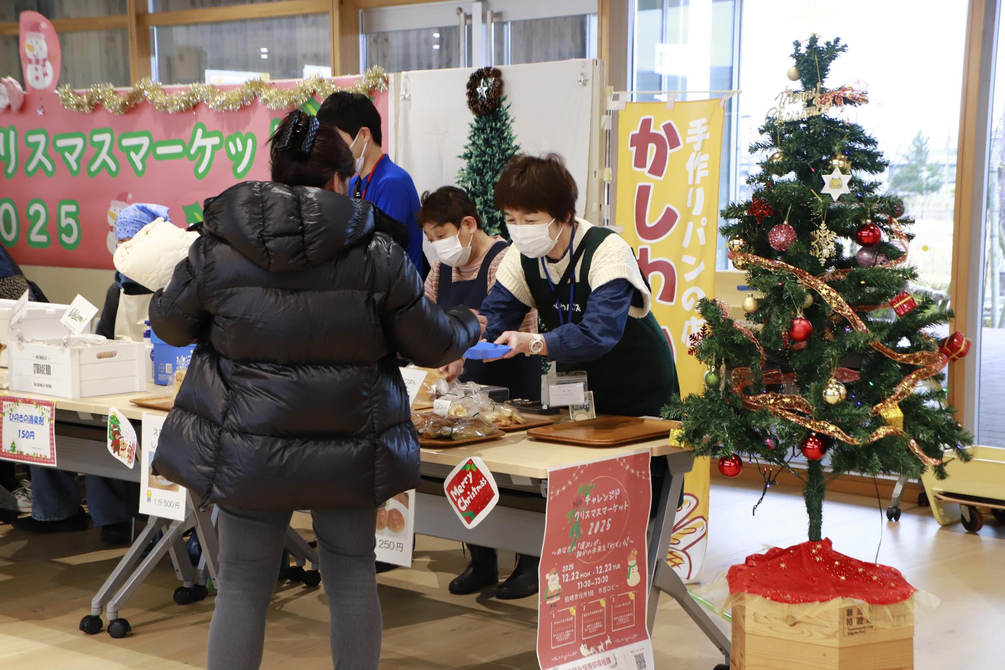 写真：かしわハンズの利用者・スタッフが、パンを販売しています。脇にはクリスマスツリーが飾られています（12月22日）