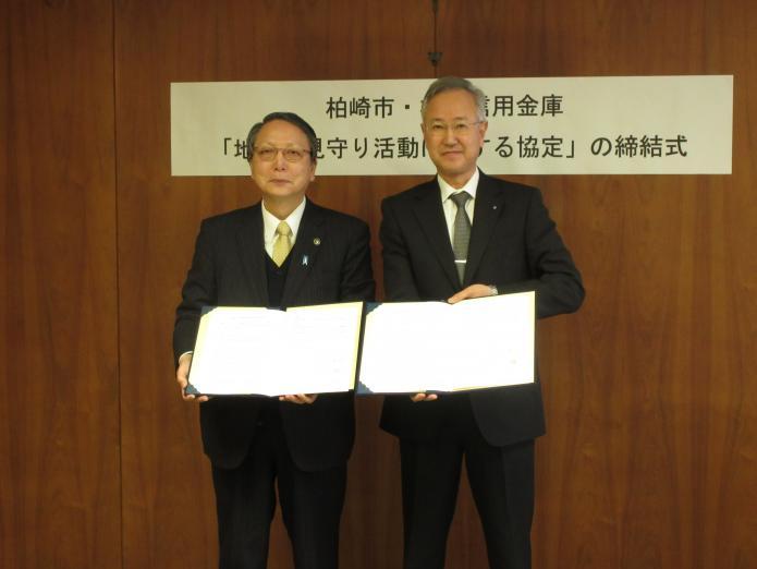 柏崎信用金庫理事長と市長が、協定書を持っている写真