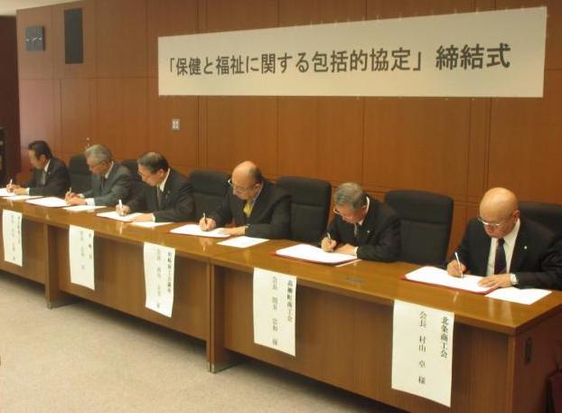 市長と市内経済団体代表者が協定書に署名をしている写真
