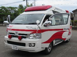 写真：柏崎総合医療センターが所有するDMATの車両。救急車に似ていますが、車体横に赤い線と「DMAT」の文字が書かれています。