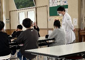 生徒に優しく問いかけながら講話をする村井医師
