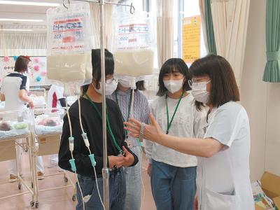 写真：点滴の交換方法を学ぶ参加児童