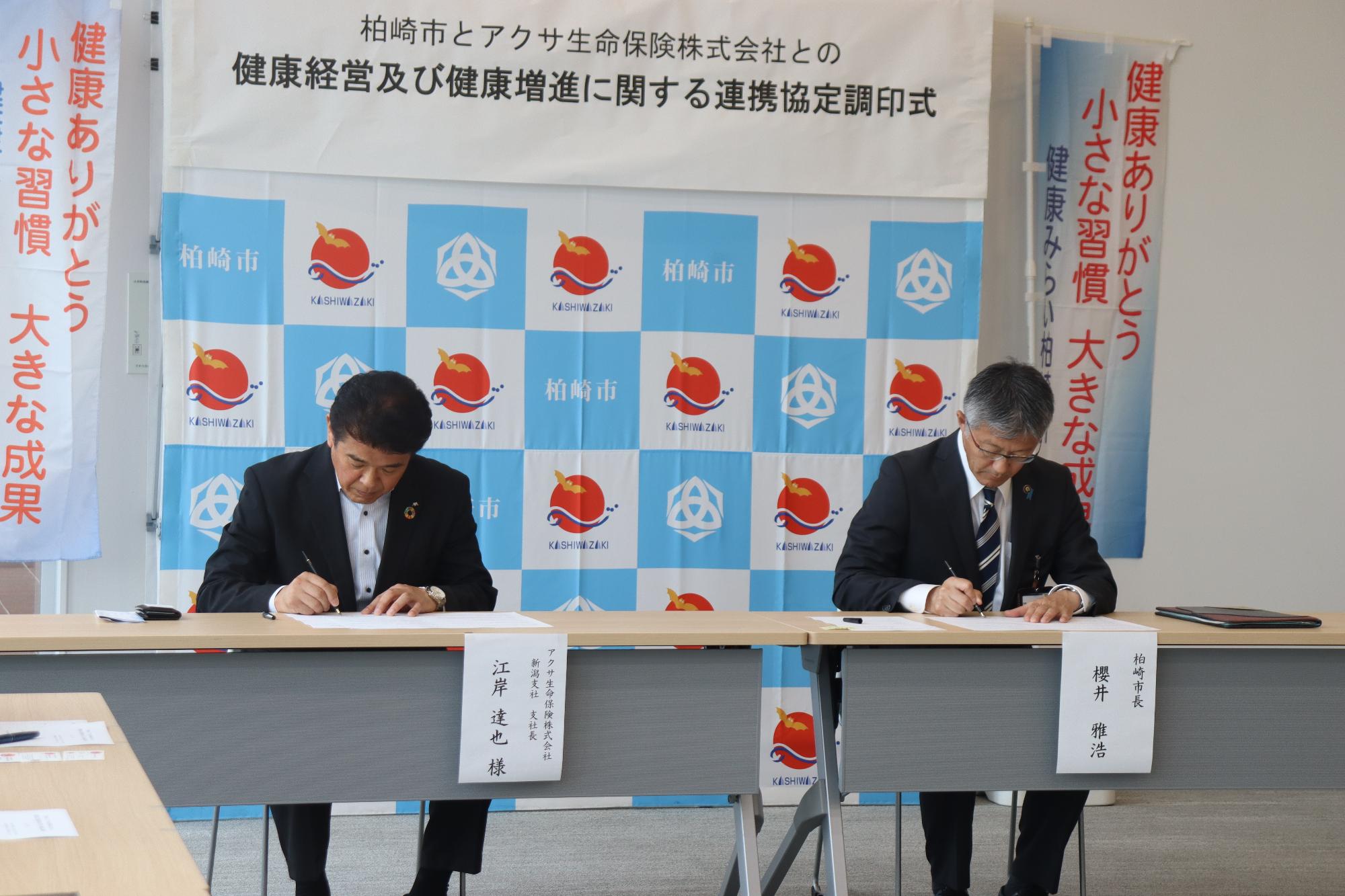 写真：桜井市長とアクサ生命保険の関係者が、協定書に署名をしています