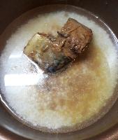 写真：米と水が入った炊飯釜に、サバの味噌煮を汁ごと入れたところ
