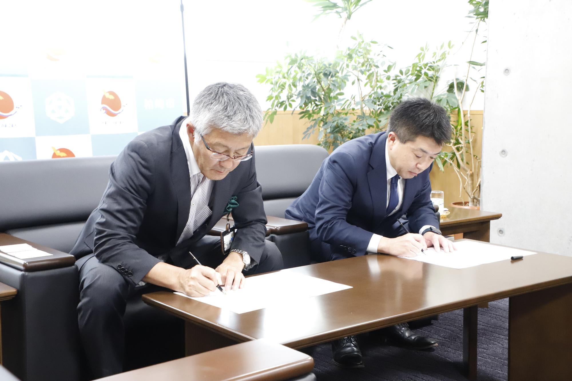 写真：桜井市長と日本生命保険相互会社関係者が、協定書に署名をしています。