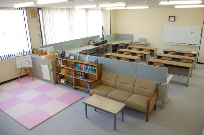 ピンクのマットや椅子、机が置かれた部屋の写真