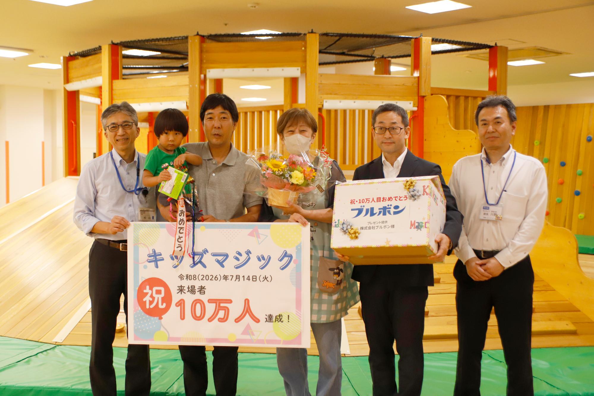 写真：キッズマジック10万人達成記念イベント。関係者から花束と副賞のお菓子が贈られました。