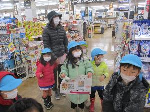 写真：お買い物リストを見ながら、店内の品物を探す4・5歳児