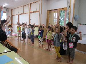写真：浦島太郎と一緒に万歳のポーズをする2歳児