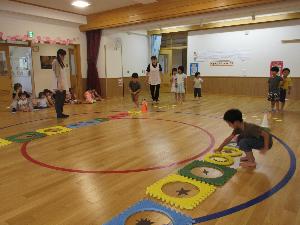 写真：七夕のゲームで盛り上がる子どもたち。プラポイントの輪の中にある物と同じ形の星を入れています。
