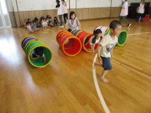 運動会の競技の練習でファニートンネルをくぐる子ども達