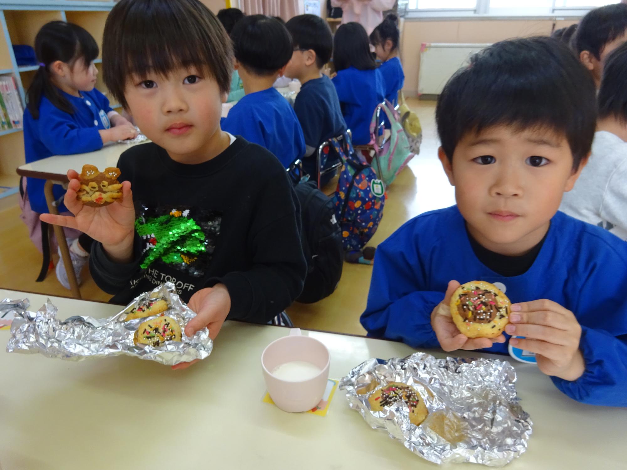 写真：年長児の2人の男の子が焼きあがったクッキーを食べている様子