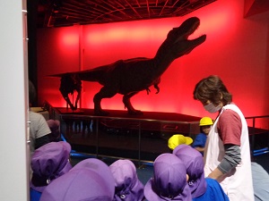 写真：大きな恐竜が動く様子を恐る恐るみる子どもたち