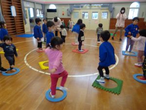 写真：笛の合図で、島に見立てたパズルマットの輪の中に入る子どもたち