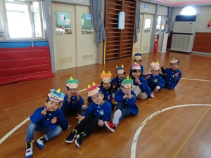 写真：3歳以上児の子どもたち10人が自分で作った鬼のお面をつけて並んでいます