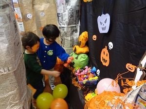 写真：子どもの背丈以上もあるハロウィンハウス内で、廃材で作った手作りのキャンディーを手にする子ども