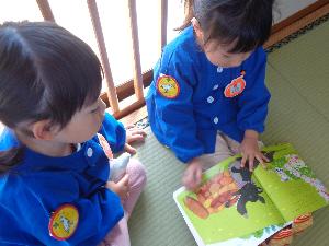 写真：友だちと一緒に絵本を読んでいる2人の子どもたち