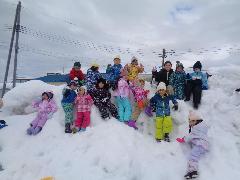 写真：雪山の上で、ポーズをとる年中児たち