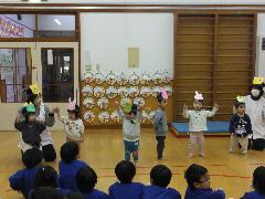 写真：十二支のお面をつけて踊るひよこ組の子どもたち
