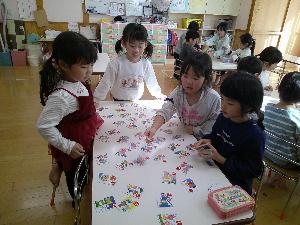 保育室でかるたをして遊んでいるぞう組の女の子4人の写真