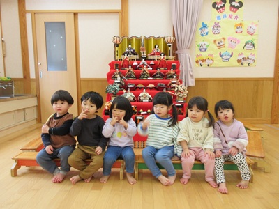 写真：ひな人形の前で座っているりす組の6人