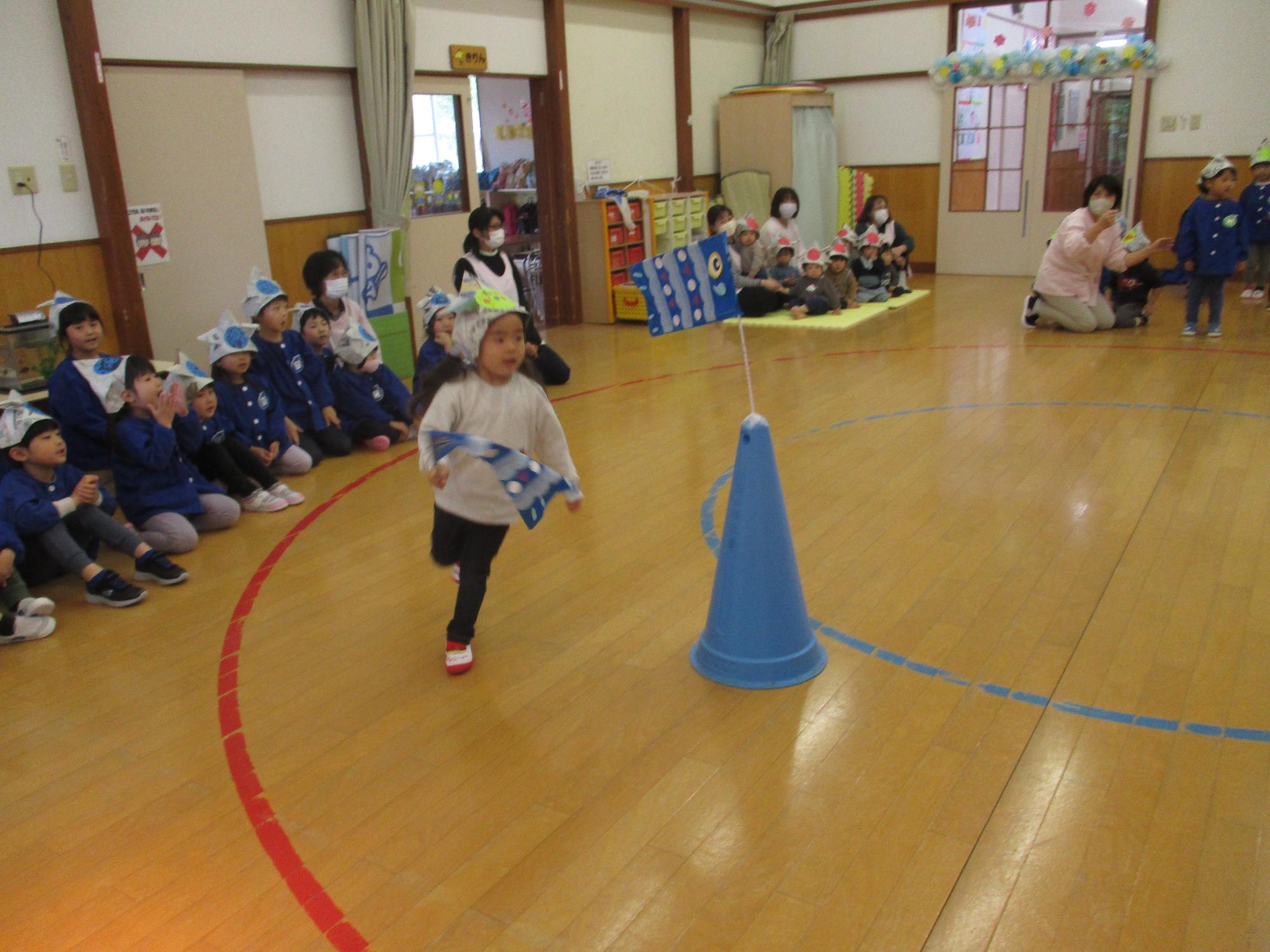 写真：新聞紙で折った紙かぶとを被り、遊戯室の中を元気に走る男の子