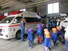 写真：消防署の車庫に止めてある救急車を見ている子どもたち