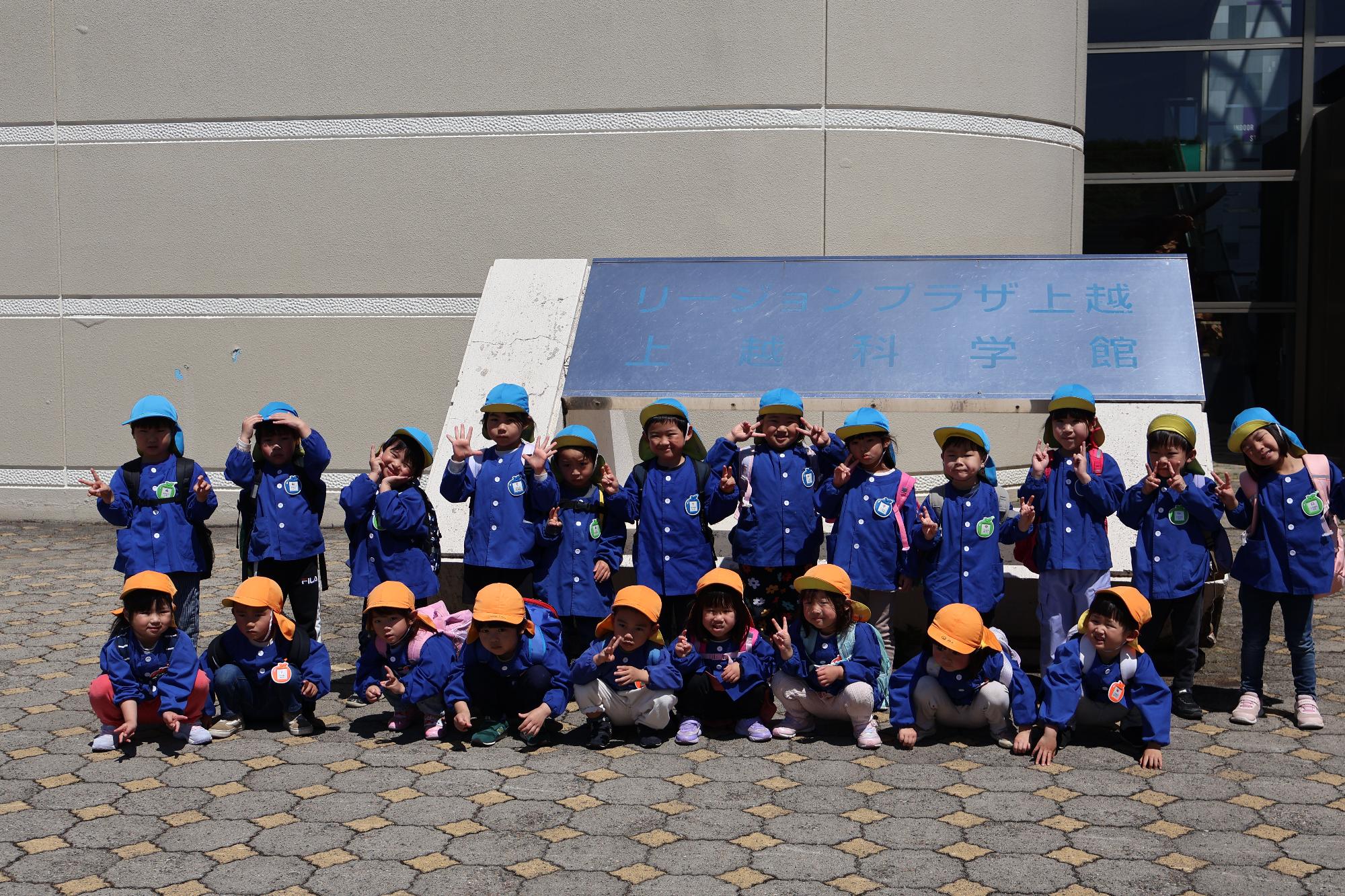 写真：上越科学館入口で記念撮影をする子どもたち