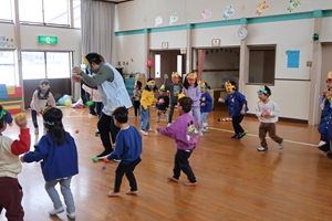 写真：鬼の到来に向け、鬼役の職員に豆を投げる練習をする子どもたち