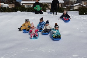 写真：なだらかな斜面を一斉に滑り降りる5人のうさぎ組2歳児