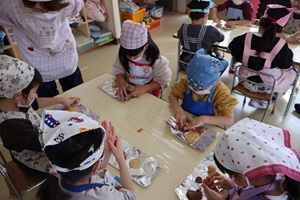写真：生地を伸ばして好きな形のクッキーを作っているきりん組の子どもたち