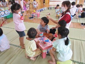 写真：えんま市ごっこで買った食べ物を座って食べる子どもたち