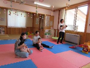 写真：お子さんを膝にのせたり抱っこしたりしながらふれあい遊びを楽しむ3組の親子