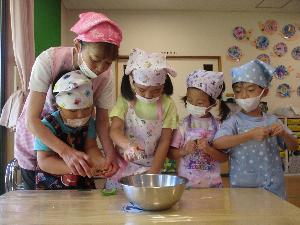 写真：5歳児4人が集中してピーマンの種を取っています