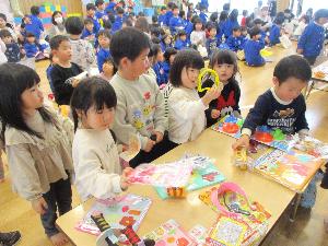 写真：2歳児が机の上に並べられたおもちゃを選んでいるところ