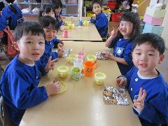 写真：焼きあがったクッキーを前に、笑顔でピースサインをするぱんだ1組の子どもたち