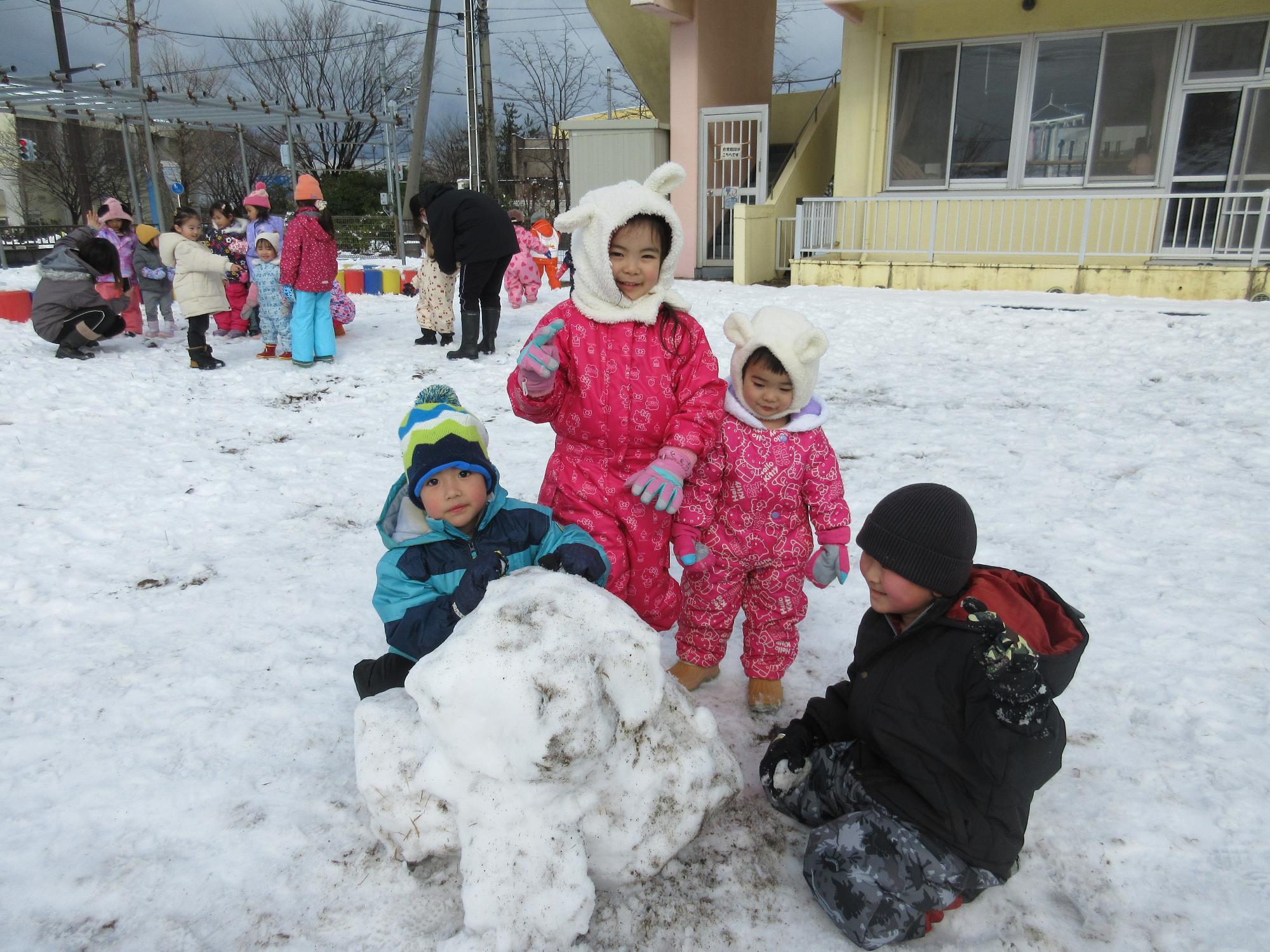 写真：子ども達が雪だるまをつくっているところ