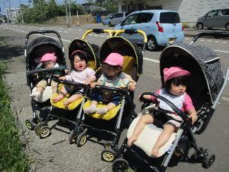 写真：ベビーカーに乗ってお散歩を楽しむ4人の0歳児