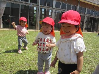 写真：ふわふわ飛ぶシャボン玉をみて、笑顔を浮かべる1歳児